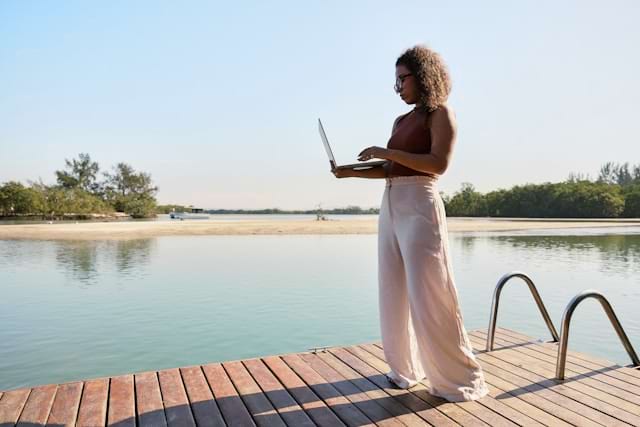 Women with laptop on a jetty